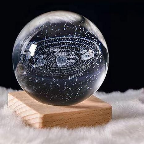 Glass sphere with solar system model on a wooden stand against a dark background. 3D crystal ball light displaying vibrant rainbow colors for mood lighting and room decor