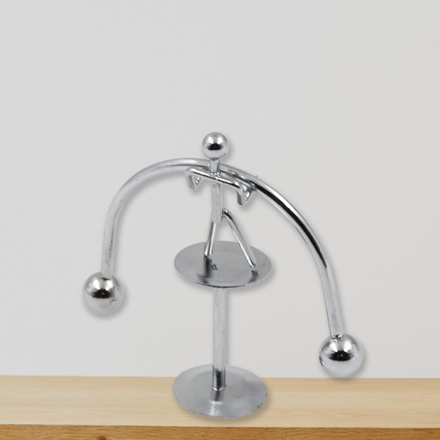 Silver metal balance man toy swinging on base, perfect desk accessory for relaxation