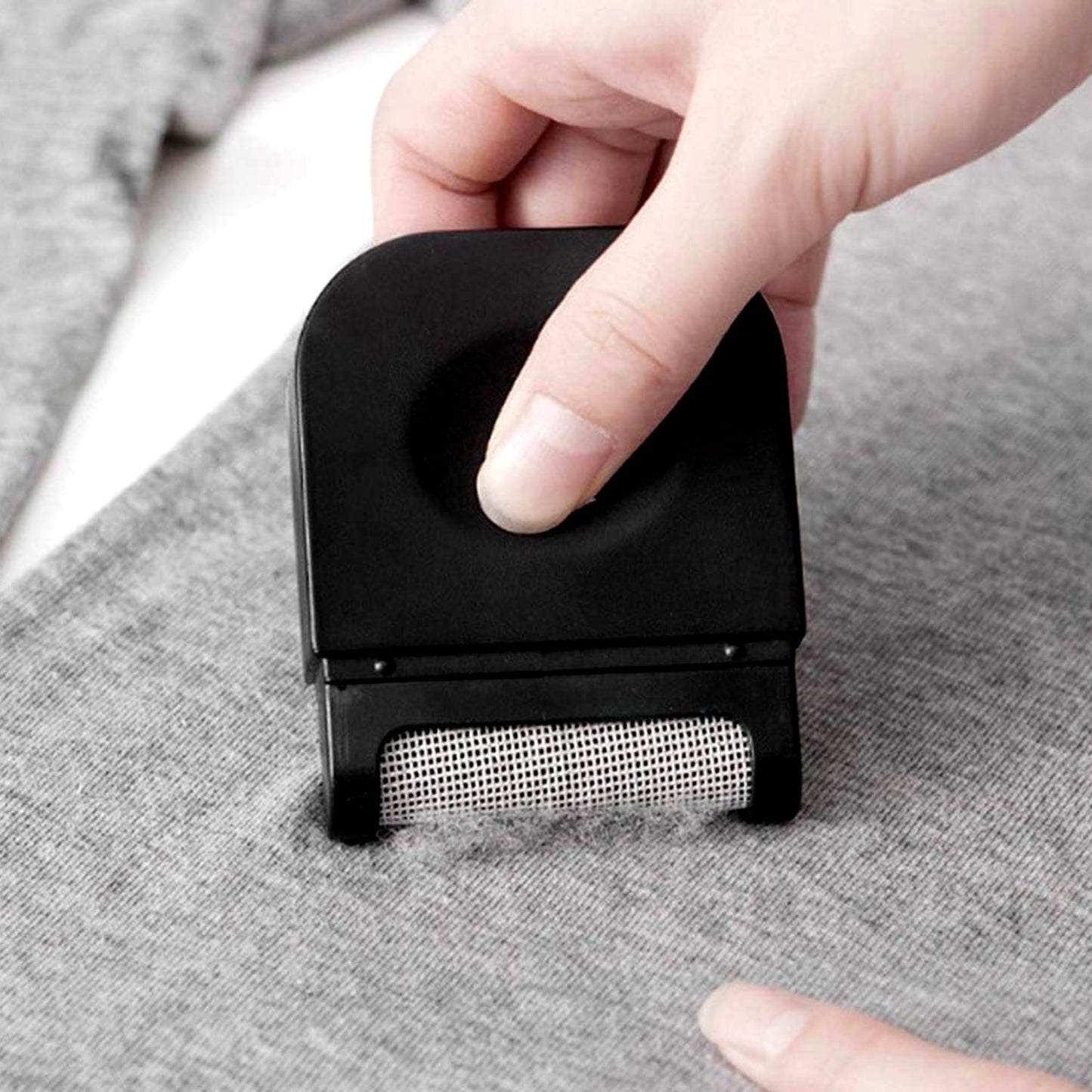 Household fabric shaver removing fuzz from sofa and curtains