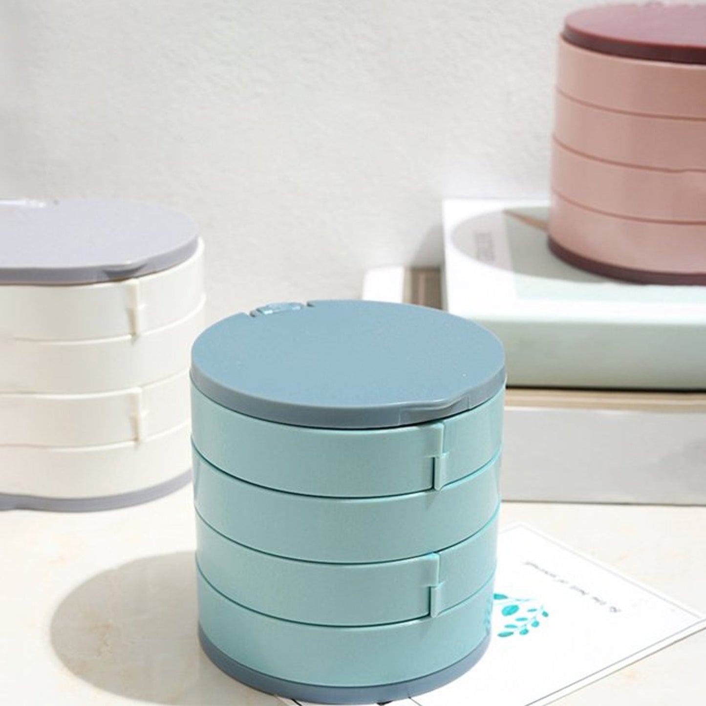 White plastic rotating jewelry storage box with mirror and cushioned compartments for delicate items