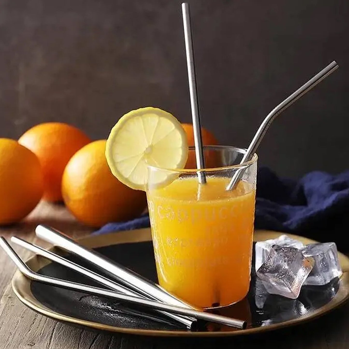 Portable stainless steel drinking straws in lemon juice glass on table