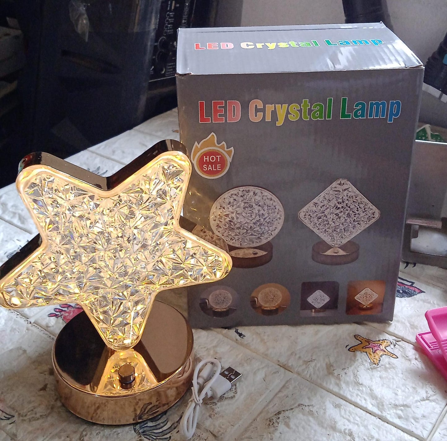 Star shape crystal diamond lamp glowing warmly on a bedside table