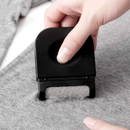 Household fabric shaver removing fuzz from sofa and curtains