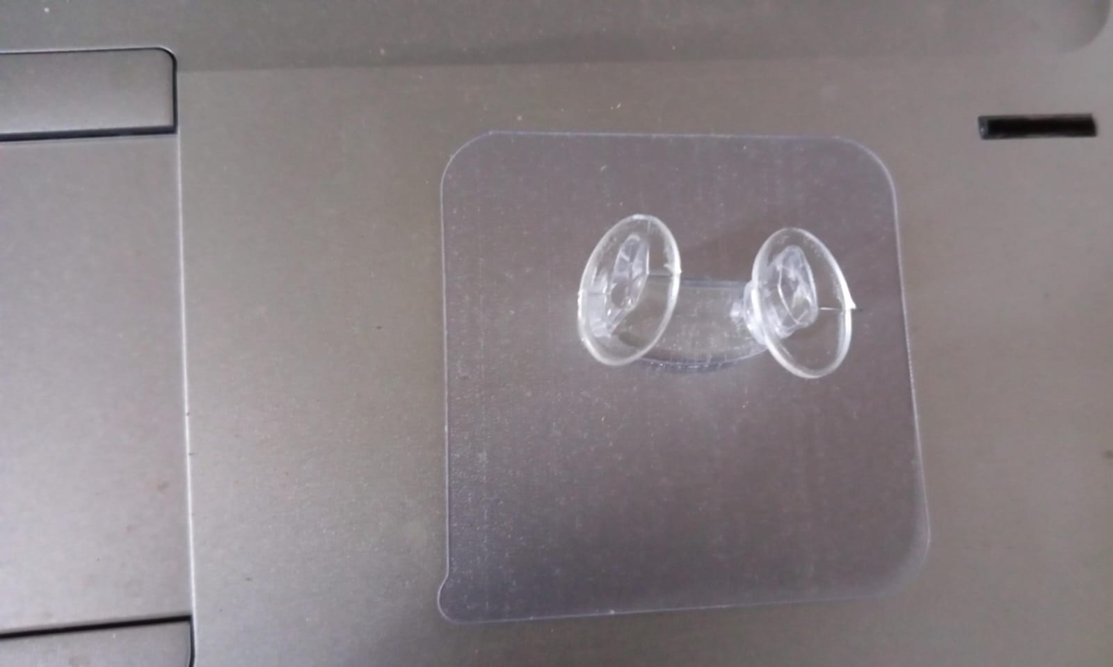 Clear adhesive wall hook used for organizing entryway items