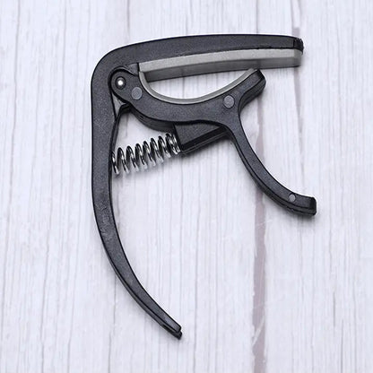 Guitar capo with pickup stand and one-hand operation pick holder, ideal for Indian music lovers