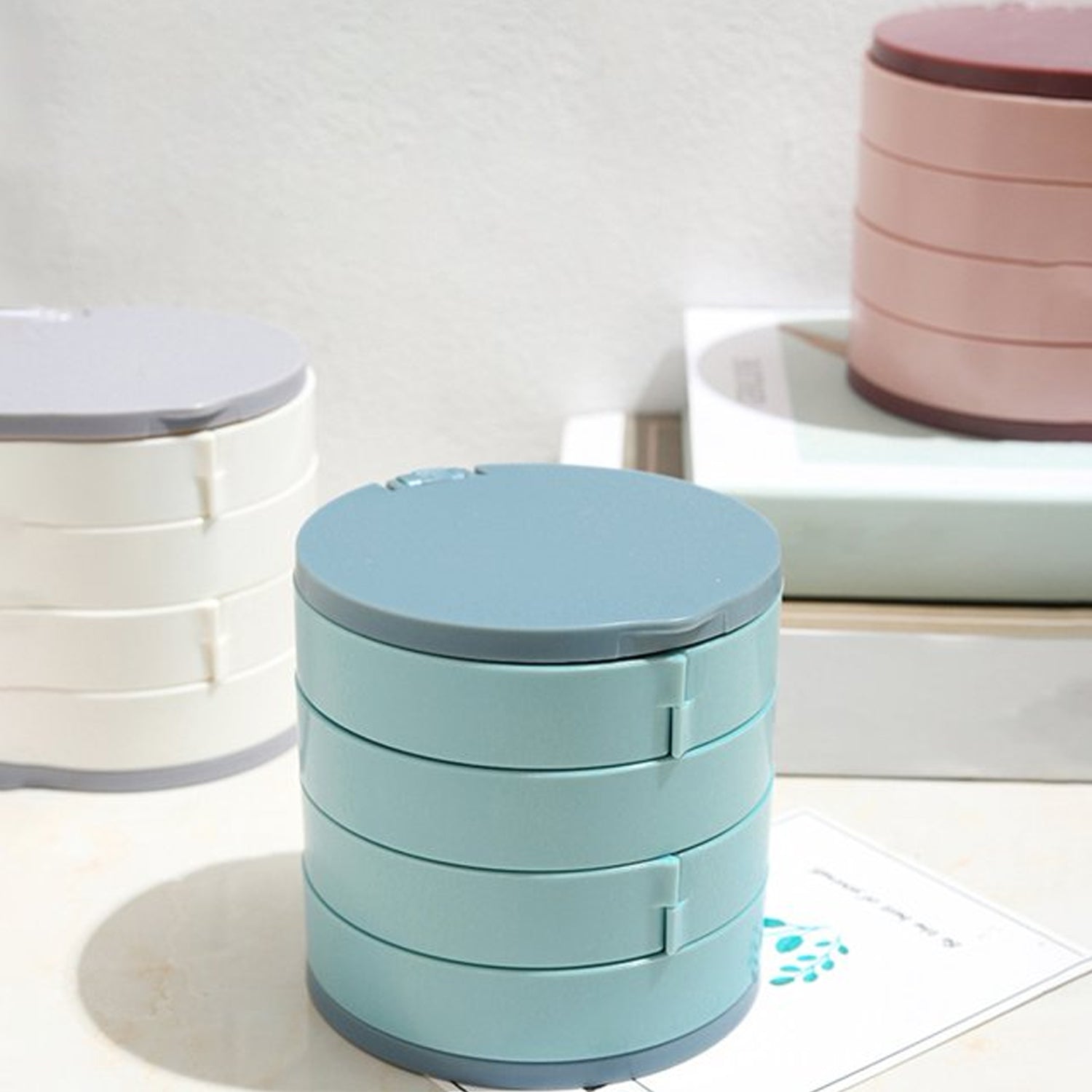 White plastic rotating jewelry storage box with mirror and cushioned compartments for delicate items