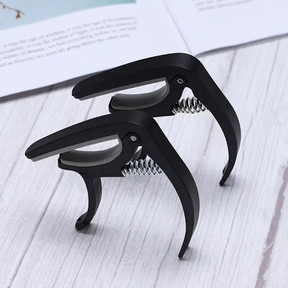 Adjustable guitar capo made from durable plastic, compatible with multiple string instruments