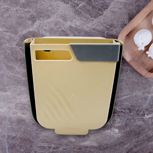 Hanging trash can mounted on kitchen cabinet door for easy waste disposal