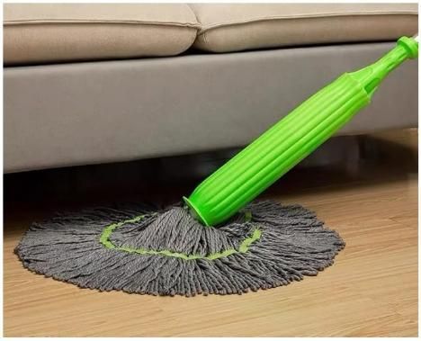 Green and gray mop cleaning under a beige sofa. Self twisting water rotating mop with 55cm extra wide microfiber head and steel handle for floor cleaning